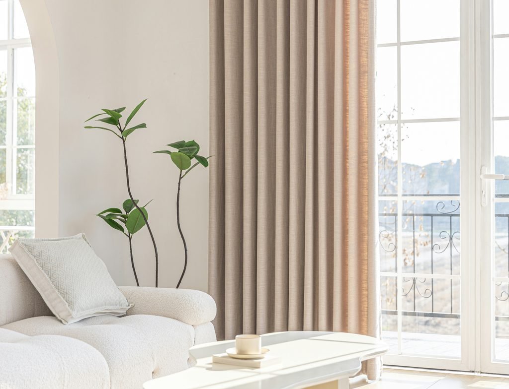 Bright living room with floor-to-ceiling neutral curtains