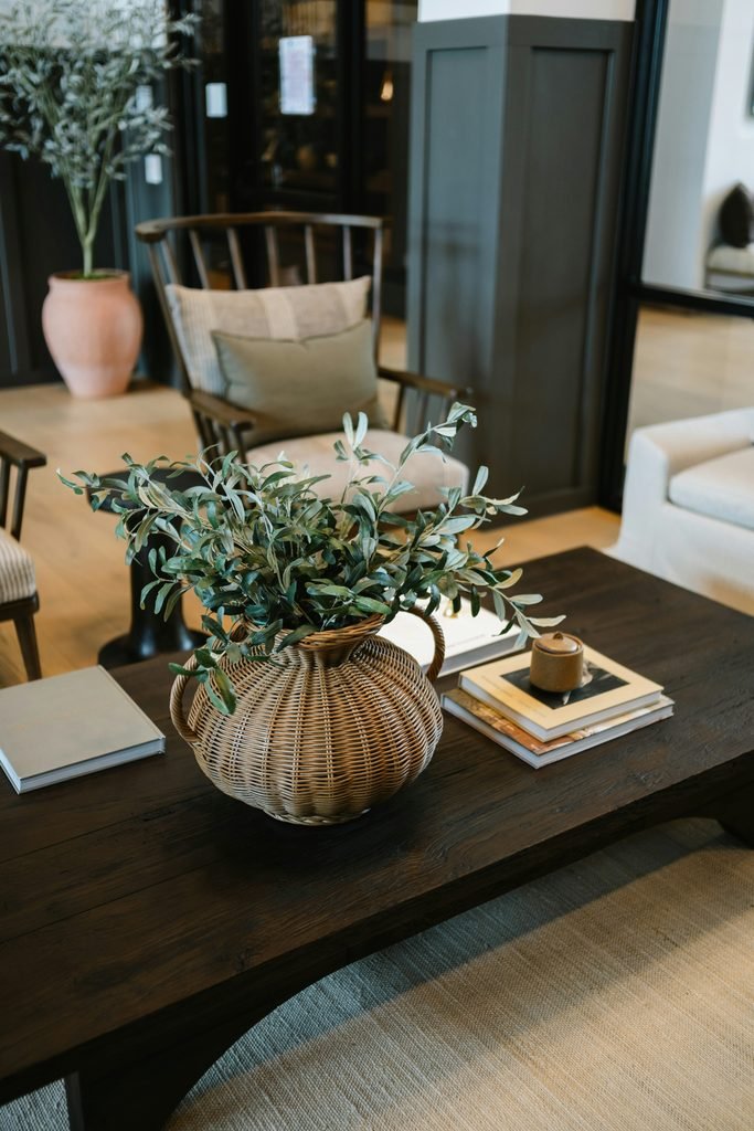 Styled coffee table with a woven vase, books, and a candle