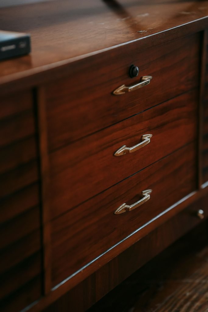 Vintage wooden dresser with warm brass handles in a cozy interior