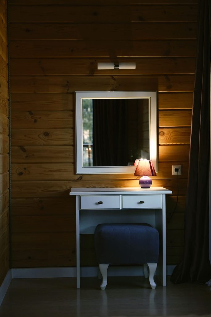 Cozy home vanity with a mirror, table lamp, and warm soft lighting