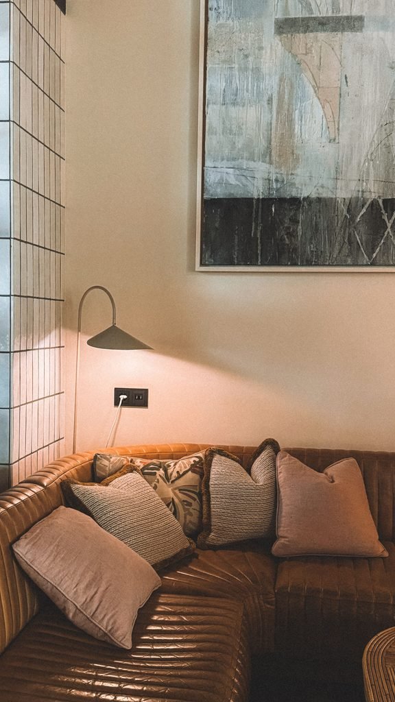Warm living room with oversized abstract artwork above a leather sofa